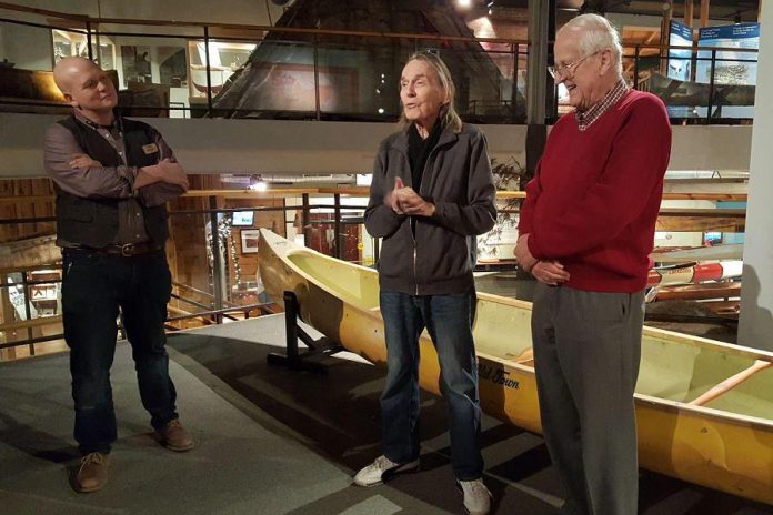 Gordon Lightfoot speaks at The Canadian Canoe Museum as museum curator Jeremy Ward (left) and Lightfoot's friend and fellow canoest Fred Gaskin looks on. The yellow canoe behind Lightfoot is one of three canoes he is donating to The Canadian Canoe Museum collection, along with one canoe donated by Gaskin. (Photo: Jeannine Taylor / kawarthaNOW.com)