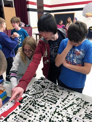 Grade 7 and 8 students at Highland Heights Public School share stories about their neighbourhood during a NeighbourPLAN Map Chat event at their school. Here, students point out areas of interest on a 3D model of their neighbourhood and share ideas about what works and where improvements could be made.   (Photo: GreenUP)