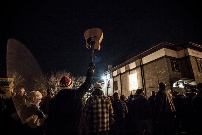 A Neil Young fan holds his guitar in the air outside Coronation Hall in Omemee, where Neil performed a solo acoustic concert to an invite-only crowd of around 200 people on December 1, 2017. Omemee resident, journalist, and writer Émilie Quesnel was in the audience after her father, a teacher at Scott Young Public School, received an invitation to the concert. (Photo: Wayne Eardley)