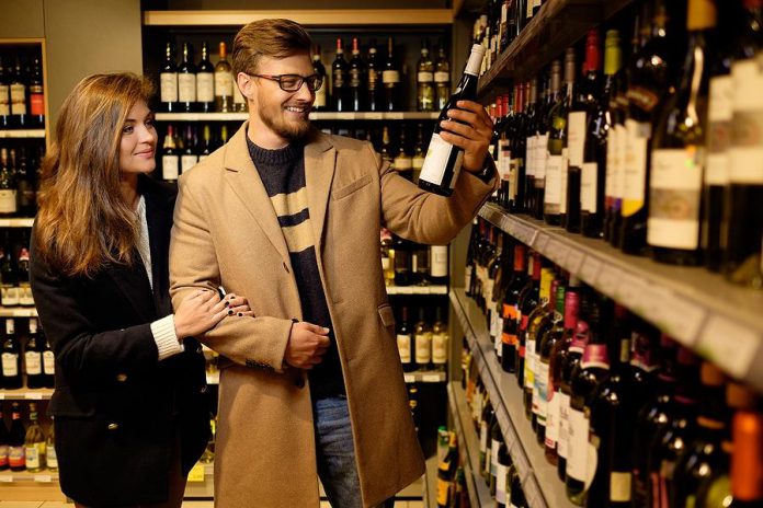 Couple buying a bottle of wine in a liquor store