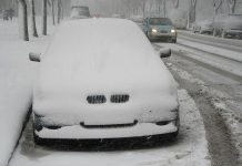 Parked car on street covered in snow