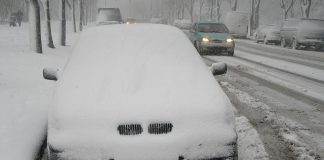 Parked car on street covered in snow