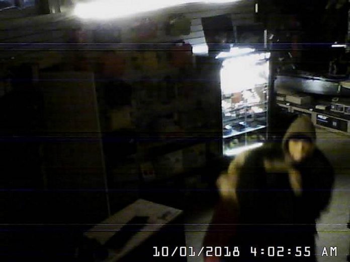 One of the thieves captured on a security camera inside the store with one of the parkas. (Photo: Wild Rock / Facebook)