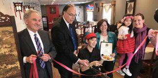 Peterborough Mayor Daryl Bennett cutting the ribbon at the official grand opening of Dragon Yan at 422 Braidwood Avenue in Peterborough on February 16, 2018, whose owner Ron Kam (seated) also made a donation to the New Canadians Centre. Also pictured are city councillors Dan McWilliams and Lesley Parnell, Kam's daughter Heidi, and Hajni Hos, executive director of the New Canadians Centre. (Photo: Daryl Bennett / Twitter)
