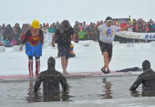 "Wonder Woman" (Andi van Koeverden, President of the Rotary Club of Peterborough), "Batman" (Trevor Copeland, President of BEL Rotary), and "Rotary Man" (Len Lifchus, President of the Rotary Club of Peterborough Kawartha) take the Polar Plunge at the annual BEL Rotary event on February 4, 2018. The event raised more than $20,000 for local charities and organizations, including $1,765 for The Warming Room in Peterborough raised through Lifchus' participation. (Photo: Lynne Chant / Rotary Club of Peterborough Kawartha)