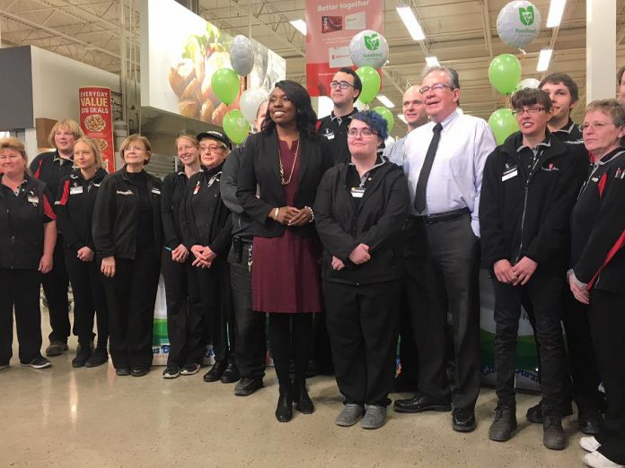 Morello’s Independent Grocer employee Amanda Gurney, who spoke about the job opportunity provided her through Employment Planning and Counselling, joins MPPs Jeff Leal and Mitzie Hunter and some of the store staff gathered for Tuesday’s Employing Young Talent Incentive announcement. (Photo: Paul Rellinger / kawarthaNOW.com)