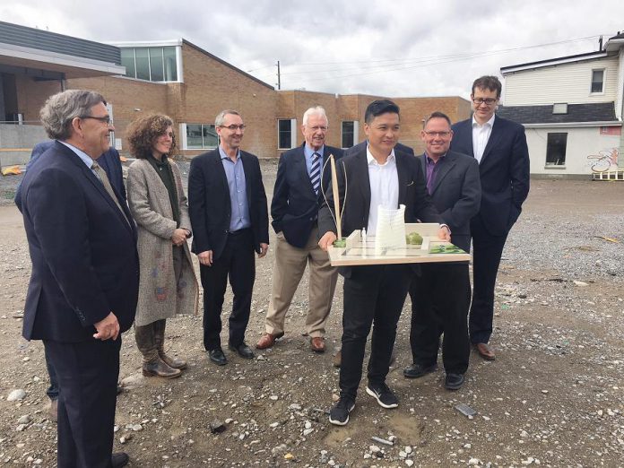 Bill Lockington of LLF Lawyers (left) joins firm partners and architect Patrick Li (holding model) at the future site of the new public square at Aylmer and Simcoe streets adjacent to the Peterborough Public Library. LLF Lawyers is providing $100,000 through  the City's Corporate Sponsorship program towards costs associated with the space's development and Li's design.  (Photo: Paul Rellinger / kawarthaNOW.com)