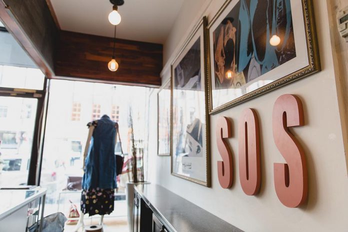 S.O.S. owner Shelby Leonard-Watt loves shoes. Those prints of shoes on the wall at the new S.0.S. store at 384 George Street in downtown Peterborough are by Andy Warhol. (Photo: Bryan Reid)