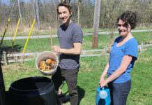 Connor Overbaugh, Summer Waste Technician with the City of Peterborough, helps Peterborough resident Jenn McCallum install a composter as part of the new partnership program with GreenUP called "Kitchen to Compost: Too Good To Waste". Peterborough residents can sign up to have a composter delivered and installed for $20. (Photo courtesy of GreenUP)