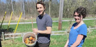 Connor Overbaugh, Summer Waste Technician with the City of Peterborough, helps Peterborough resident Jenn McCallum install a composter as part of the new partnership program with GreenUP called "Kitchen to Compost: Too Good To Waste". Peterborough residents can sign up to have a composter delivered and installed for $20. (Photo courtesy of GreenUP)