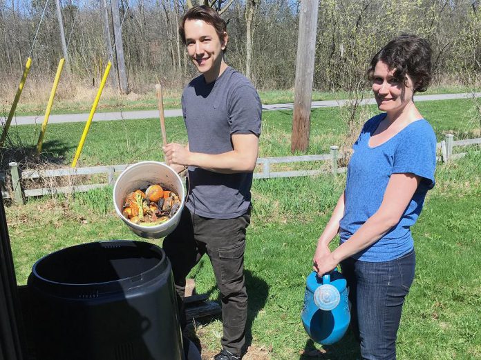 Connor Overbaugh, Summer Waste Technician with the City of Peterborough, helps Peterborough resident Jenn McCallum install a composter as part of the new partnership program with GreenUP called "Kitchen to Compost: Too Good To Waste". Peterborough residents can sign up to have a composter delivered and installed for $20. (Photo courtesy of GreenUP)