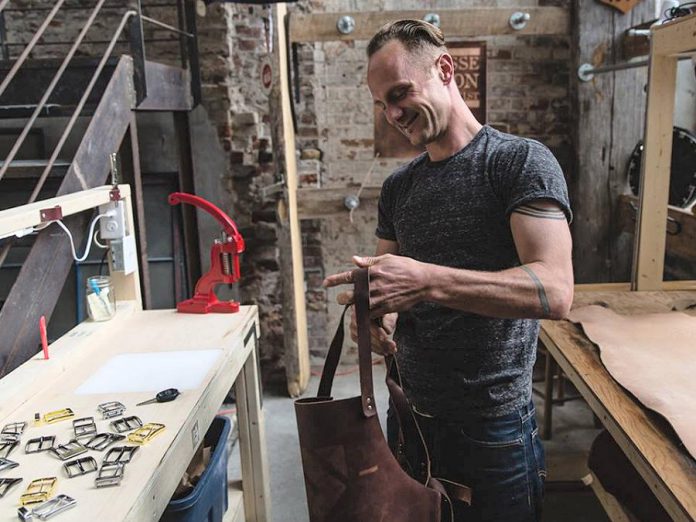 Jesse Bateson, owner and operator of Solid Leather, in his workshop. Bateson, who produces stylish and durable handmade solid leather belts, is one of seven local entrepreneurs who have received a grant under Starter Company Plus, a provincially funded business development program delivered by Peterborough & the Kawarthas Business Advisory Centre. (Photo: Solid Leather / Facebook)