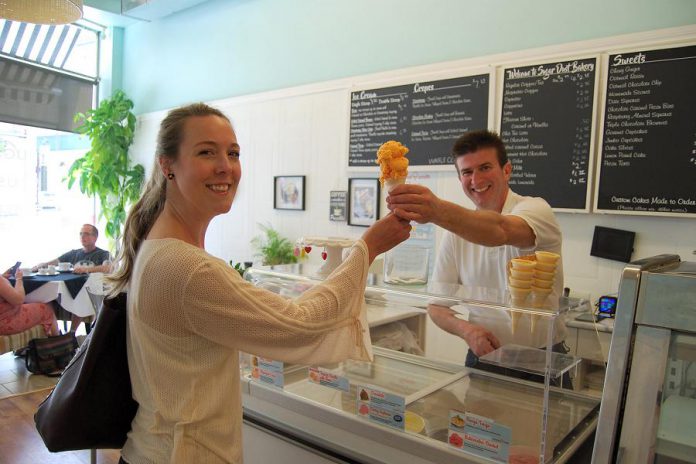 Sugar Dust Bakery & Cafe co-owner George Mangos hands an ice cream cone to customer Samantha Guigue, who decided to treat herself after donating to the pay-it-forward program. (Photo: April Potter / kawarthaNOW.com)