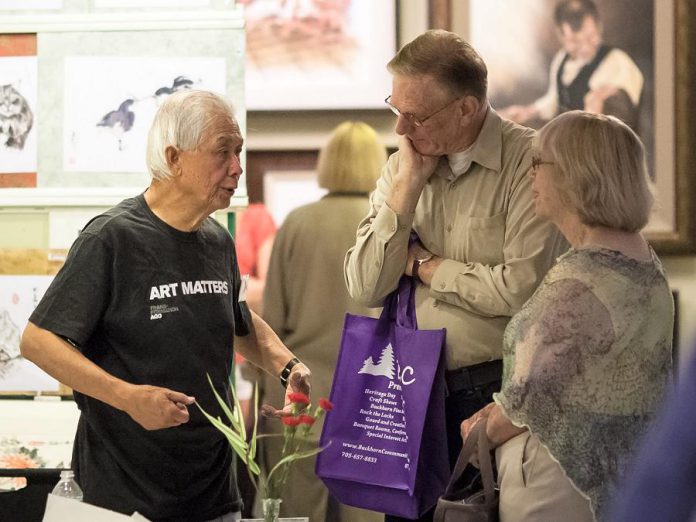 Artist Charles Leung, an alumni exhibitor with the Buckhorn Fine Art Festival, chats with attendees at the Buckhorn Fine Art Festival. (Photo courtesy of Buckhorn Fine Art Festival)