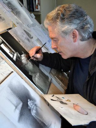 Famed Canadian wildlife artist Michael Dumas, one of the founding members of the Buckhorn Fine Art Festival, at work on "Looking Out". The original graphite study is the featured painting in "The Lives of Birds" and is one of two prize draws on opening night on Friday, August 17. (Photo courtesy of Buckhorn Fine Art Festival)