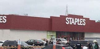 Paramedics treat a woman who was shot on August 22, 2018 in the parking lot of the Home Depot on Lansdowne Street West in Peterborough (enhanced from a photo posted by Joe Keating on Twitter).