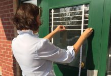 Many millions of birds in Canada die each year from collisions with windows. Ewa Bednarczuk, Ecology & Stewardship Specialist with Lower Trent Conservation, applies small white adhesive markers to window glass on a door. The markers are spaced to provide a visual cue to birds that the window is not open space. (Photo courtesy of Lower Trent Conservation)