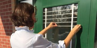 Many millions of birds in Canada die each year from collisions with windows. Ewa Bednarczuk, Ecology & Stewardship Specialist with Lower Trent Conservation, applies small white adhesive markers to window glass on a door. The markers are spaced to provide a visual cue to birds that the window is not open space. (Photo courtesy of Lower Trent Conservation)