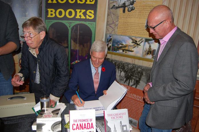 Historian and playwright Hugh Brewster, who wrote the play "Last Day, Last Hour - Canada's Great War on Trial" which will be performed during Armistice 18, signs a book during the opening ceremony on Sunday, September 30, 2018. (Photo: April Potter / kawarthaNOW.com)