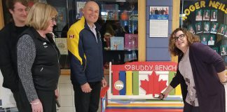 Roger Neilson Public School principal Denise Humphries (right) cuts the ribbon on the Rotary Buddy Bench as Nate Loch, Rotarian Donna Geary, and Rotary Club of Peterborough Kawartha president Brian Prentice look on. Geary and her son Nate initiated the Rotary Buddy Bench program in Peterborough last year, donating a bench to St. Catherine's Catholic Elementary School in Peterborough. (Photo: Rotary Club of Peterborough Kawartha)