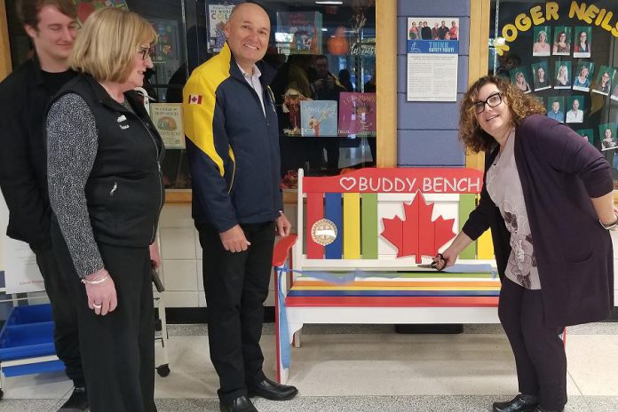 Roger Neilson Public School principal Denise Humphries (right) cuts the ribbon on the Rotary Buddy Bench as Nate Loch, Rotarian Donna Geary, and Rotary Club of Peterborough Kawartha president Brian Prentice look on. Geary and her son Nate initiated the Rotary Buddy Bench program in Peterborough last year, donating a bench to St. Catherine's Catholic Elementary School in Peterborough. (Photo: Rotary Club of Peterborough Kawartha)