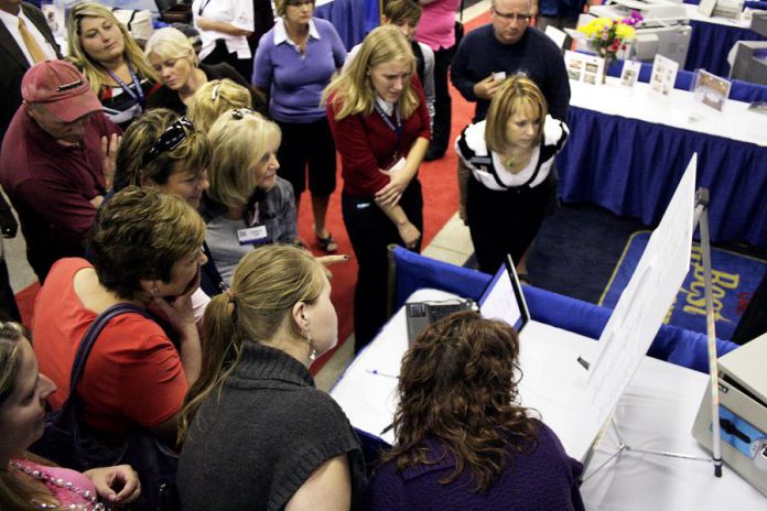 People gather around a display at Love Local Expo, the region's largest business trade show, in 2016. For the first time ever, this year's Love Local Expo takes place at the Evinrude Centre in Peterborough. Featuring more than 90 local businesses, Love Local Expo runs from noon to 7 p.m. on Wednesday, October 3, 2018. The event is free, there's lots of free parking, and there will be prizes including a notebook computer. (Photo: Peterborough Chamber of Commerce)