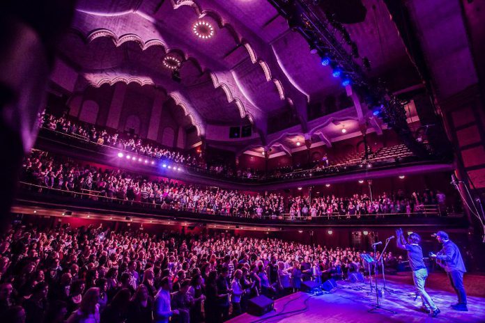 Choir! Choir! Choir! co-founders Nobu Adilman and Daveed Goldman on stage at Massey Hall in Toronto. Adilman and Goldman will lead an audience at Market Hall in Peterborough in a performance of Leonard Cohen's "Hallelujah" (and more) on October 5, 2018. (Photo: Joseph Fuda)