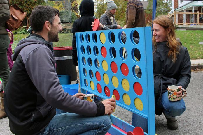 Two attendees of the Sophia Street Pulse Pop-up play giant board games that were set up on the street by Boardwalk Game Lounge, who will soon be opening soon in downtown Peterborough. (Photo: Karen Halley)