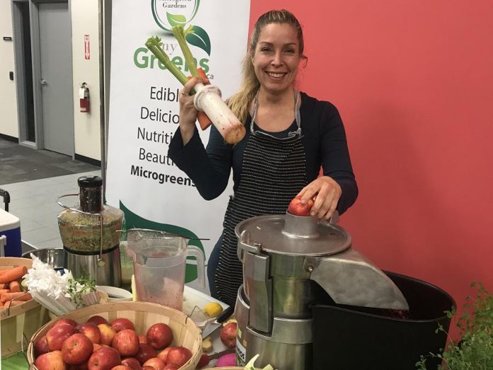 Tina Bromley from Tiny Green Plant Cafe juices at the new indoor market. Bromley loveed the warmth and the bright colours of the new winter location, as well as the enthusiasm of market patrons on the opening day.  (Photo: Barb Shaw / kawarthaNOW.com)