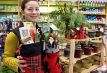 Store associate Tabetha Graham showcases many of the green stocking stuffers under $25 offered at the GreenUP Store, where all items are carefully sourced to meet high environmental standards.