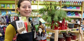 Store associate Tabetha Graham showcases many of the green stocking stuffers under $25 offered at the GreenUP Store, where all items are carefully sourced to meet high environmental standards.