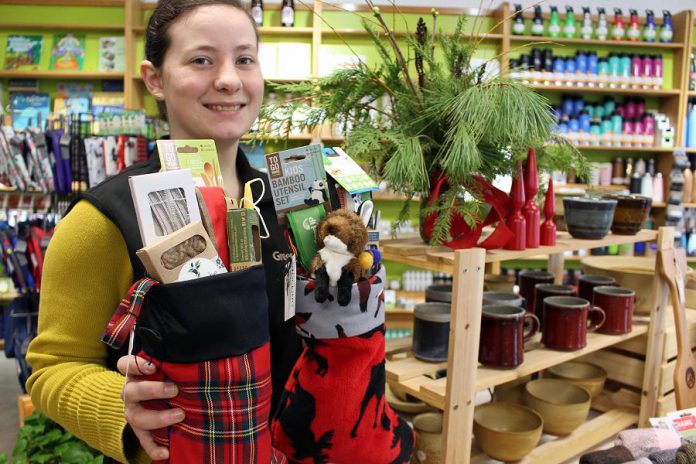 Store associate Tabetha Graham showcases many of the green stocking stuffers under $25 offered at the GreenUP Store, where all items are carefully sourced to meet high environmental standards.