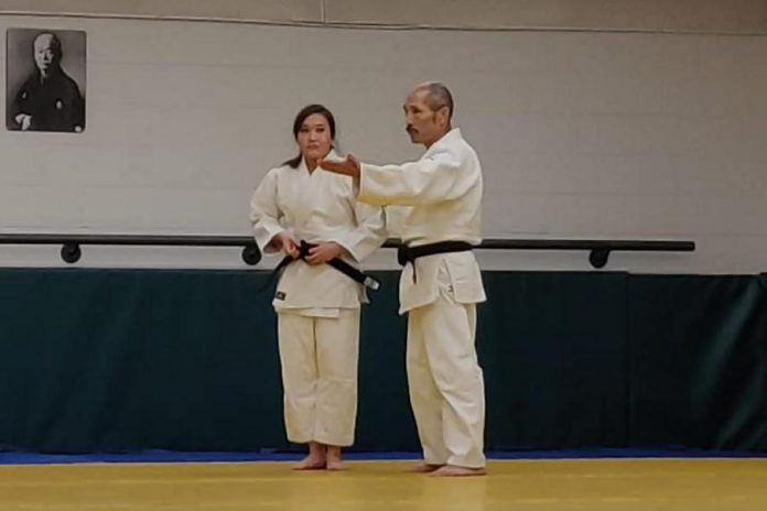 Sarah Miller with sensei Tom Hino. Pictured on the wall in the background is Kano Jigoro, the Japanese educator and athlete who founded judo in 1883. (Supplied photo)