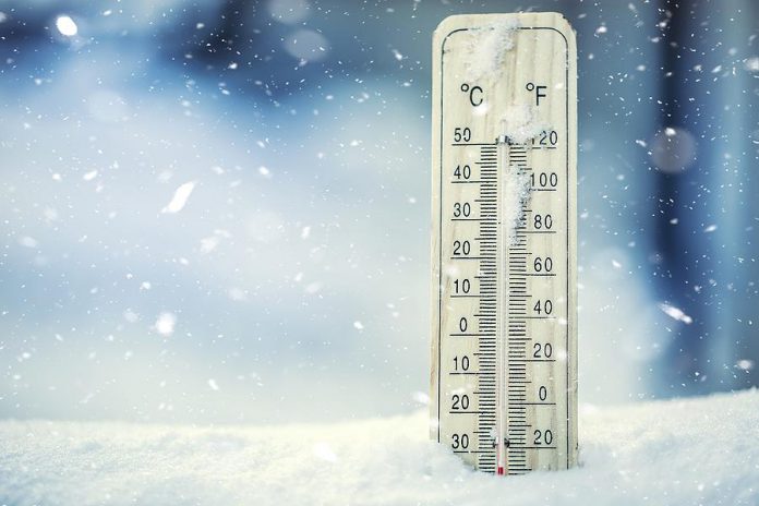 Extreme cold shown on thermometer in snow