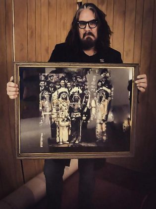 Tom Wilson holds a photo of his great-grandfather bringing a peace pipe to Parliament Hill, part of a diorama Wilson has created for his exhibit "Beautiful Scars: Mohawk Warriors, Hunters and Chiefs: The Art of Tom Wilson", which runs at the Art Gallery of Burlington until January 27, 2019. (Photo: Tom Wilson / Facebook)