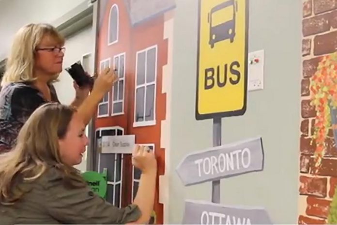 Art School of Peterborough exeutive director Jenni Johnston and volunteer Lori work on a mural in the C3 inpatient unit of Peterborough Regional Health Centre (PRHC). Last fall, a team of 16 volunteers with the art school painted for three days per week over two months to create the murals. (Screenshot from PRHC video)