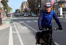 Jaime Akiyama, GreenUP's Transportation and Urban Design Program Coordinator, rides her bike along the George Street bike lane in Peterborough, with her panniers loaded up after shopping downtown. (Photo courtesy of GreenUP)