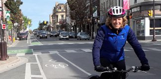 Jaime Akiyama, GreenUP's Transportation and Urban Design Program Coordinator, rides her bike along the George Street bike lane in Peterborough, with her panniers loaded up after shopping downtown. (Photo courtesy of GreenUP)