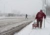 Older woman walking in a winter snow storm