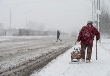 Older woman walking in a winter snow storm