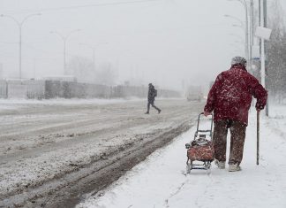Older woman walking in a winter snow storm