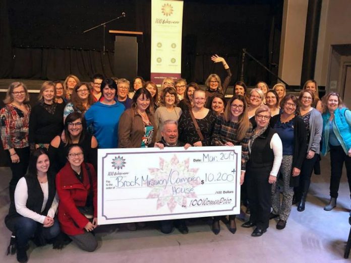 rock Mission executive director Bill McNabb (centre) celebrates the collective donation of more than $10,200 from members of the 100 Women Peterborough group at The Venue in downtown Peterborough on March 19, 2019. Brock Mission is the fifth local organization to receive a donation of at least $10,000 from group since its formation in early 2018. (Photo: Rosalea Terry)