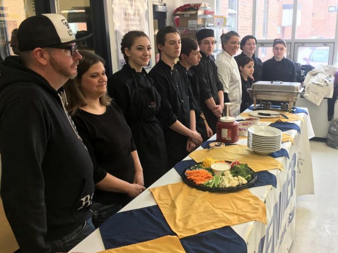 Juke Box Mania co-chairs Brad and Katie Watt (left), owners of Rare Grill, were joined by Kenner Collegiate culinary arts students and culinary arts teacher and Black Honey owner Lisa Dixon on Tuesday (March 5) for the official opening of registration for the April 26 music trivia-based fundraiser for Community Counselling and Resource Centre. (Photo: Paul Rellinger / kawarthaNOW.com)