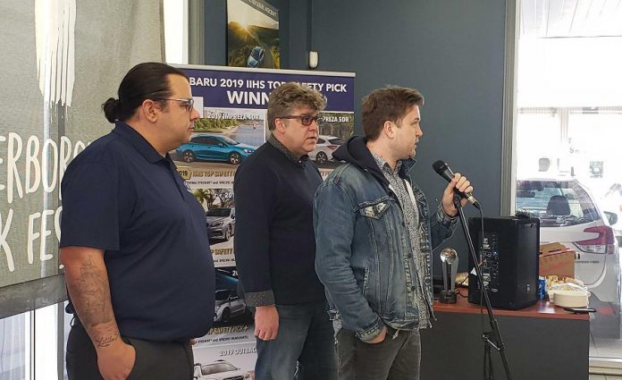 Peterborough Folk Festival board vice chair and artistic director  Ryan Kemp (right) announces a partnership with Peterborough Subaru at the car dealership's showroom on Chemong Road on March 19, 2019.  Peterborough Subaru is sponsoring the 2019 Peterborough Folk Festival, which takes place for four days from August 15th to 18th.  The main stage at Nicholls Oval Park in East City will be called the "Peterborough Subaru Stage". Also pictured are Peterborough Subaru  sales and marketing specialist Phillip Jolicoeur (left) and Peterborough Folk Festival board chair Malcolm Byard.  (Photo: Jeannine Taylor / kawarthaNOW.com)