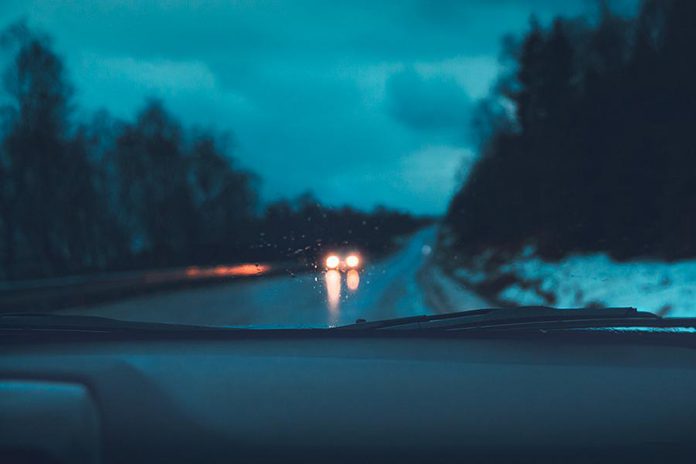 Rain and snow through a car's windshield at night