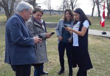 Selwyn Township mayor Andy Mitchell, Peterborough mayor Diane Therrien, and Peterborough-Kawartha MP Maryam Monsef (right) explore the Random Acts of Green mobile app as the social enterprise's founder and CEO Jessica Correa looks on, at the April 18, 2019 announcement of $200,000 in federal funding from the Climate Action Fund. The funding will help Random Acts of Green to develop and promote the mobile app, which measures and rewards Canadians for their 'green acts' to reduce greenhouse gas emissions. (Photo: Office of Andy Mitchell)