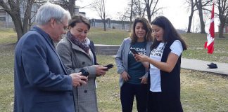 Selwyn Township mayor Andy Mitchell, Peterborough mayor Diane Therrien, and Peterborough-Kawartha MP Maryam Monsef (right) explore the Random Acts of Green mobile app as the social enterprise's founder and CEO Jessica Correa looks on, at the April 18, 2019 announcement of $200,000 in federal funding from the Climate Action Fund. The funding will help Random Acts of Green to develop and promote the mobile app, which measures and rewards Canadians for their 'green acts' to reduce greenhouse gas emissions. (Photo: Office of Andy Mitchell)