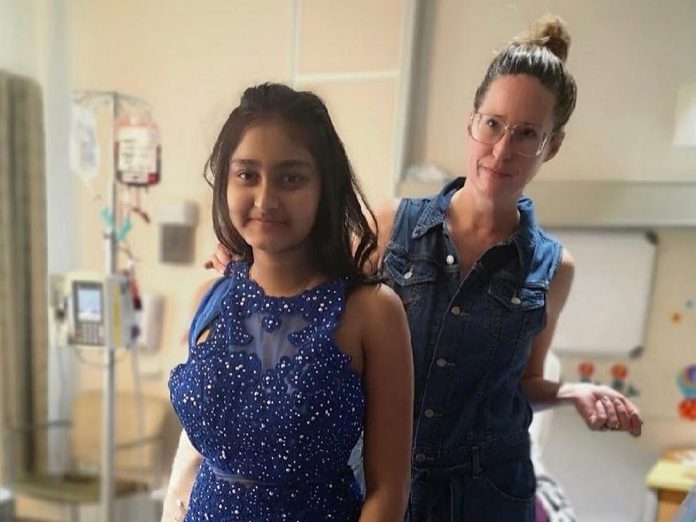 Save Our Soles owner Shelby Watt, helps 13-year-old Kristey, a cancer patient at Peterborough Regional Health Centre, try on a dress. (Photo: Peterborough Regional Health Centre / @prhc1 Instagram)