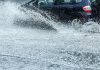 Car on flooded road during heavy rain