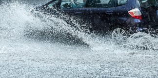 Car on flooded road during heavy rain